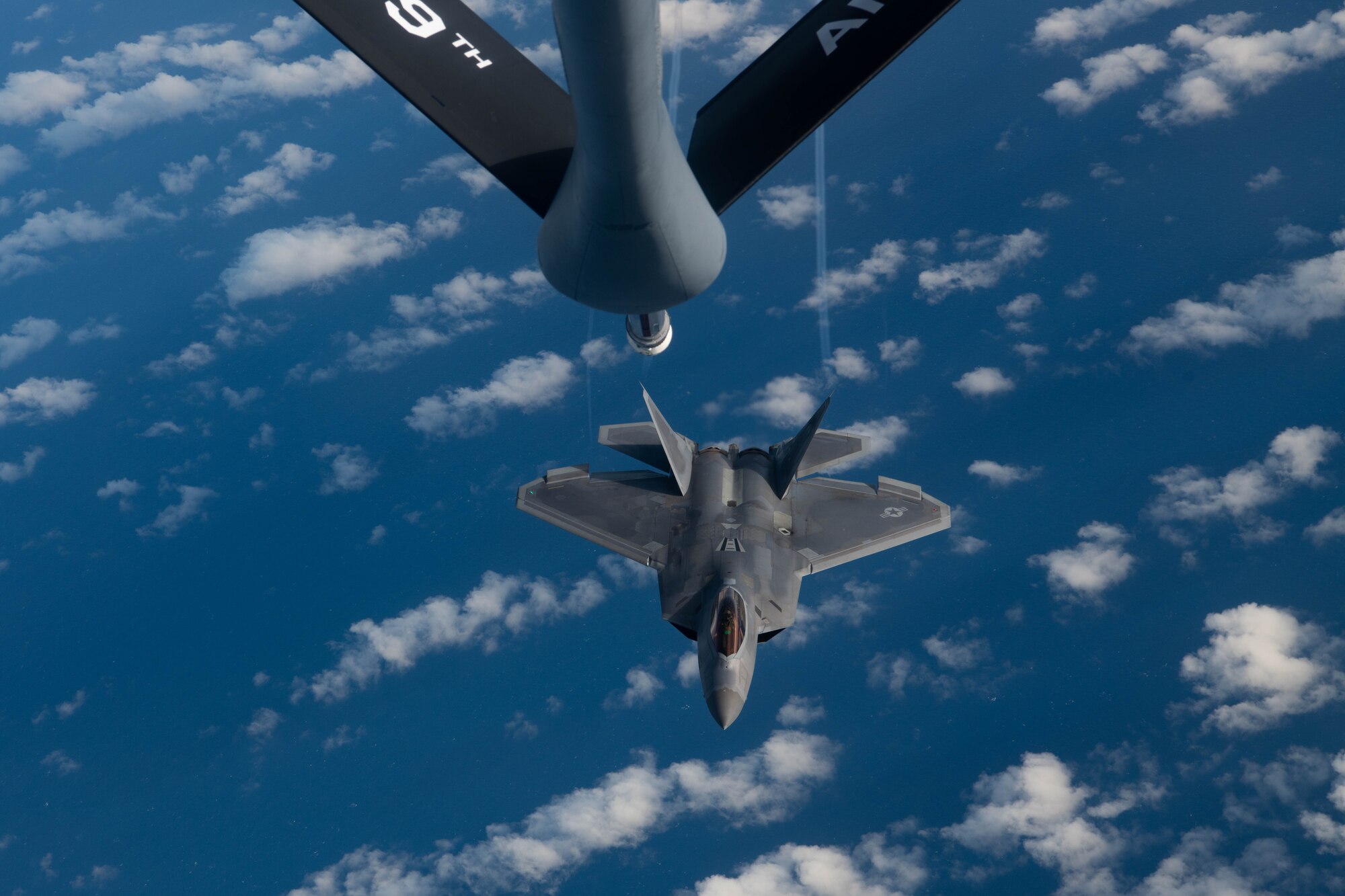 A jet gets refueled in the air.