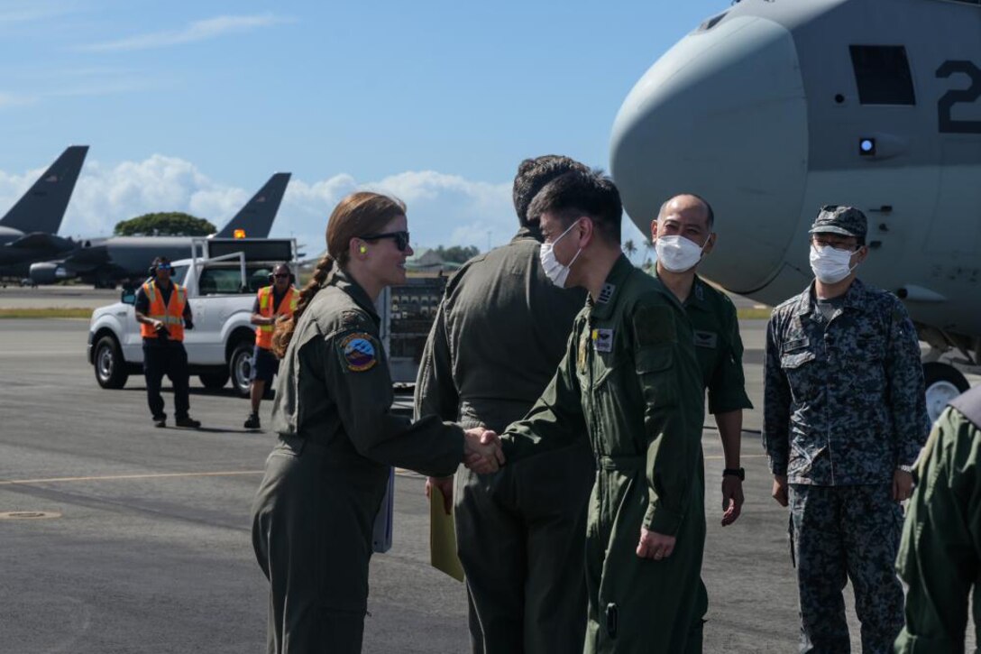 A female service member shakes hands with a male service member.