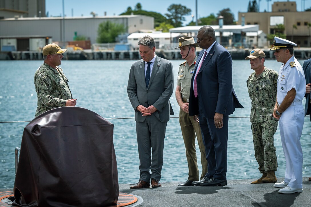 Men tour a submarine.