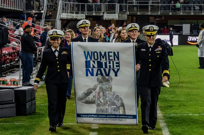 WASHINGTON (Oct. 01, 2022) - Chief of Naval Operations Adm. Mike Gilday and Sailors and civilians assigned to Navy Sea Systems command participate in the halftime parade during a National Women's Soccer League game at Audi Field where the Washington Spirit highlighted Women in the Navy (WIN), Oct. 1. During the game, between the Washington Spirit and the Houston Dash, Navy women, which included Sailors and civilians, were recognized on the field for their service. (U.S. Navy photo by Mass Communication Specialist 1st Class Michael B. Zingaro/released)