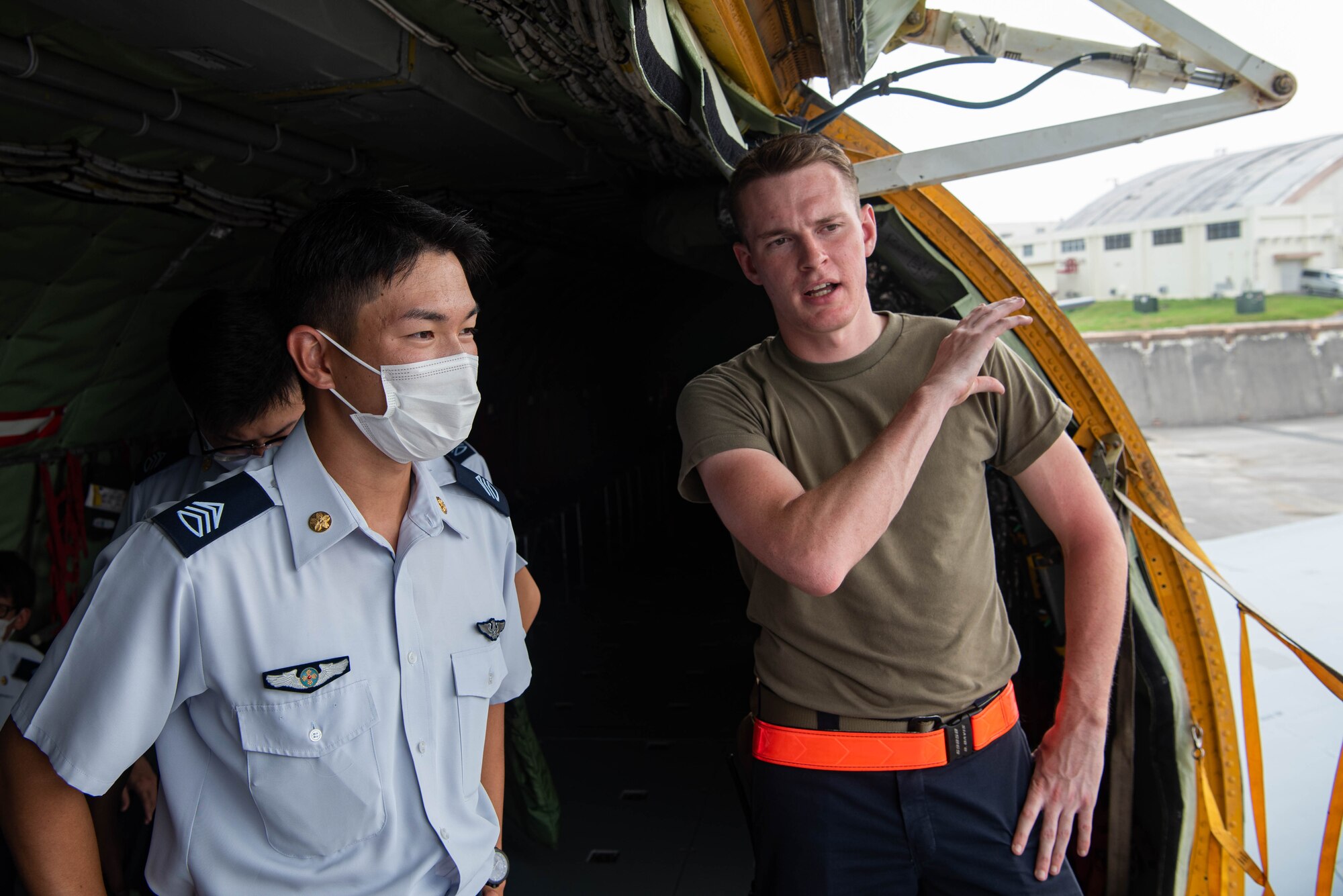 An Airman and JASDF cadet discuss aircraft maintenance.