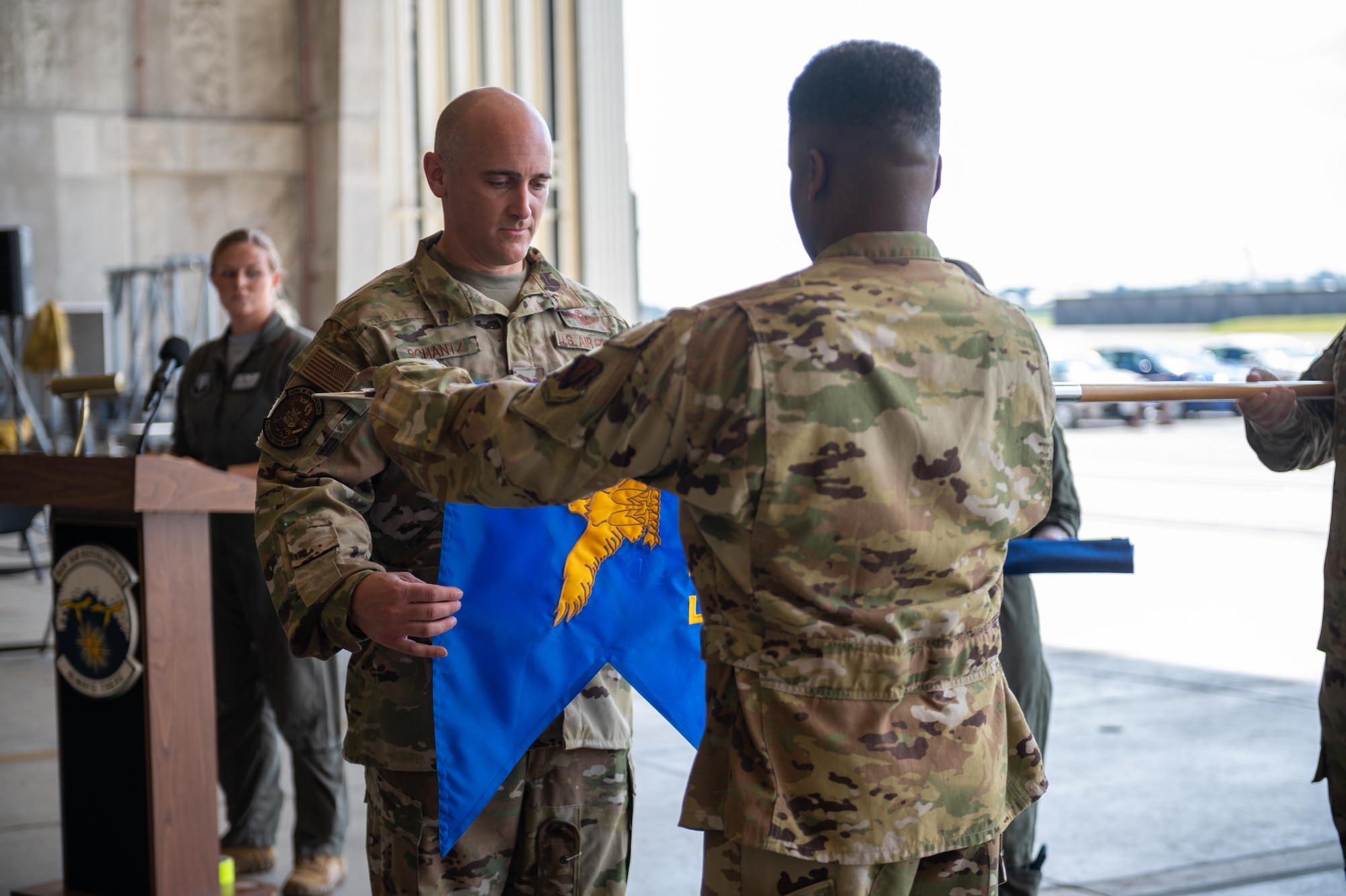 Commanders furl the 5th Expeditionary Airborne Command and Control Squadron guidon during the 5th EACCS deactivation ceremony