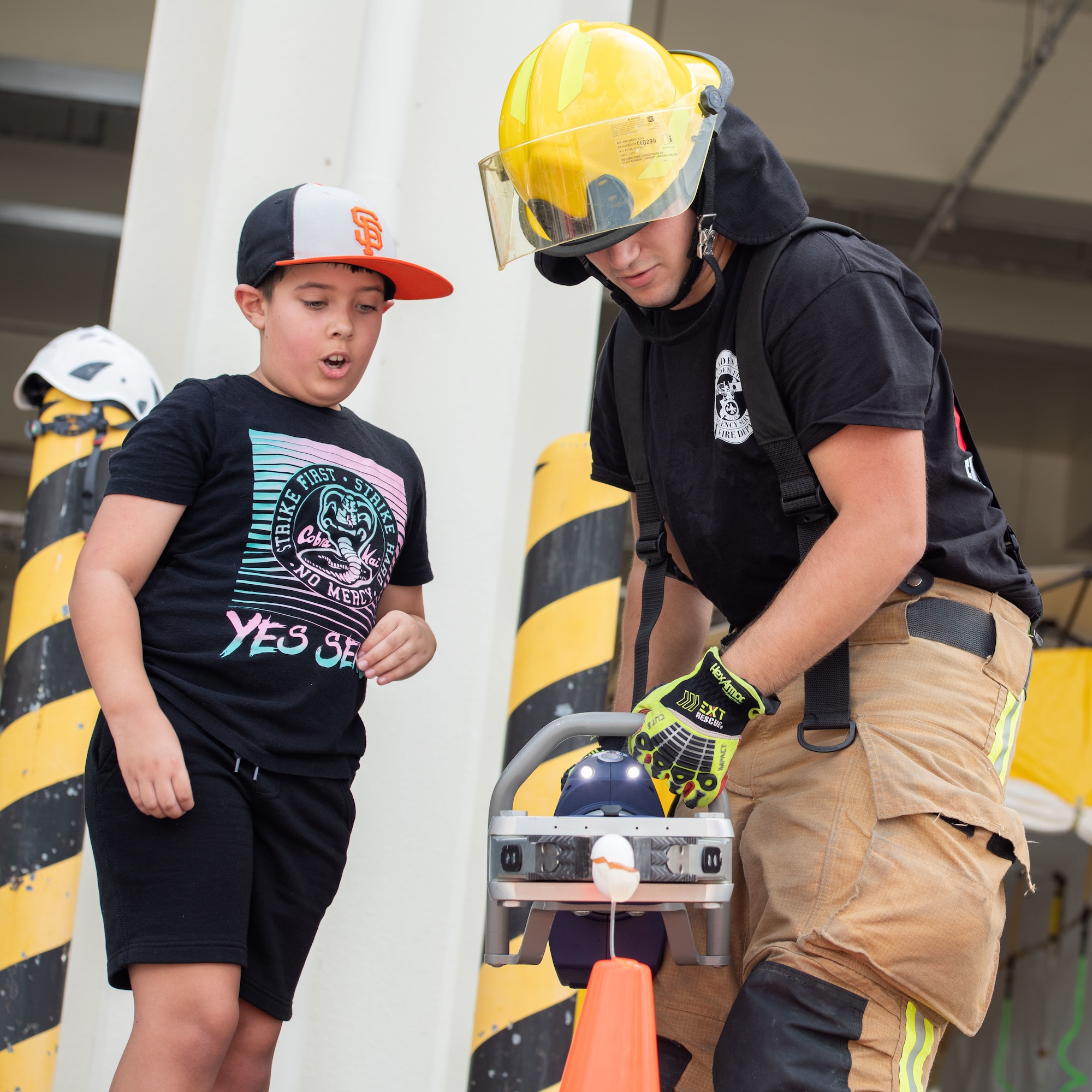 Firefighter demonstrates a fire hose to a child
