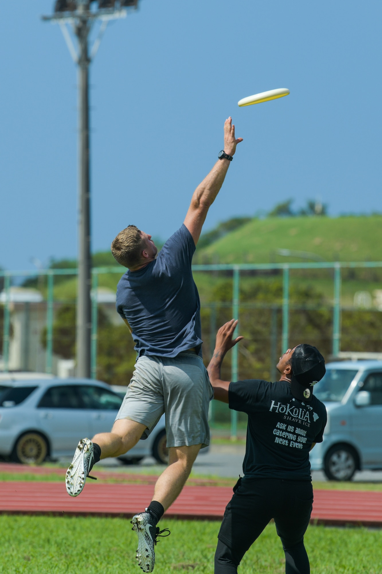 Airmen try to catch a frisbee during a game.
