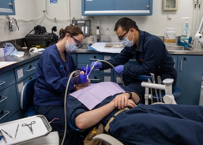 221001-N-ET093-2012 ADRIATIC SEA (Oct. 1, 2022) Lt. Rosalyn Nardella, left, and Hospitalman Jason Ong, perform routine dental work on Lt. James Gloria, all assigned to the Nimitz-class aircraft carrier USS George H.W. Bush (CVN 77) during a dental check-up, Oct. 1, 2022. The George H.W. Bush Carrier Strike Group is on a scheduled deployment in the U.S. Naval Forces Europe area of operations, employed by U.S. Sixth Fleet to defend U.S., allied and partner interests. (U.S. Navy photo by Mass Communication Specialist Seaman Curtis Burdick)