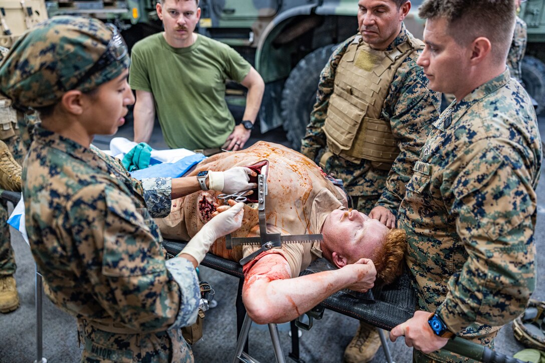 U.S. Navy Lt. Cmdr. Marissa Mayor, a general surgeon with 2nd Medical Battalion, 2nd Marine Logistics Group, in support of Special Purpose Marine Air-Ground Task Force UNITAS LXIII simulates surgery on a Marine while aboard the amphibious transport dock ship USS Mesa Verde (LPD 19) at a surgical training event during exercise UNITAS LXIII in the Atlantic Ocean, Sept. 17, 2022. The training event consisted of Marines patrolling, taking simulated casualties, and simulated lifesaving surgery. UNITAS trains forces to conduct joint maritime operations through the execution of anti-surface, anti-submarine, anti-air, amphibious and electronic warfare operations that enhance warfighting proficiency and increase interoperability among participating navy and marine forces.  (U.S. Marine Corps photo by Cpl. Ryan Schmid)