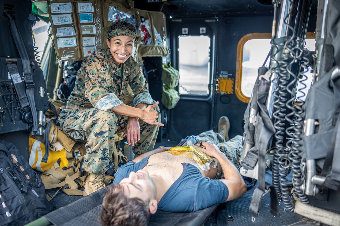 U.S. Navy Lt. Cmdr. Marissa Mayor, a general surgeon with 2nd Medical Battalion, 2nd Marine Logistics Group, in support of Special Purpose Marine Air-Ground Task Force UNITAS LXIII poses for a picture on a UH-1Y Venom with her surgical instruments while aboard the amphibious transport dock ship USS Mesa Verde (LPD 19) during a surgical training event during exercise UNITAS LXIII in the Atlantic Ocean, Sept. 17, 2022. The training event consisted of Marines patrolling, taking simulated casualties, and simulated lifesaving surgery. UNITAS, which is Latin for “unity,” was conceived in 1959 and has taken place annually since first conducted in 1960. This year marks the 63rd iteration of the world’s longest-running annual multi-national maritime exercise. Additionally, this year Brazil celebrated its bicentennial, a historical milestone commemorating 200 years of the country’s independence. (U.S. Marine Corps photo by Cpl. Ryan Schmid)