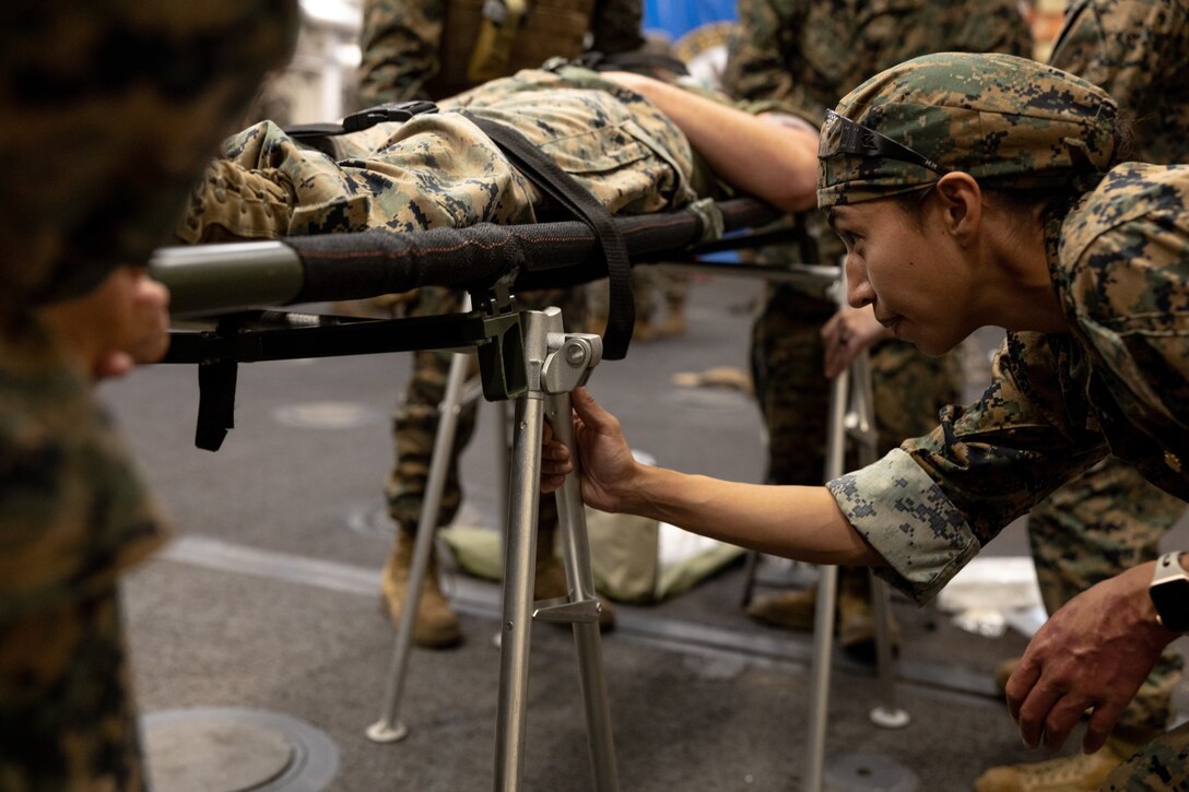 U.S. Navy Lt. Cmdr. Marissa Mayor, a general surgeon with 2nd Medical Battalion, 2nd Marine Logistics Group, in support of Special Purpose Marine Air-Ground Task Force UNITAS LXIII adjusts the stands for a litter aboard the amphibious transport dock ship USS Mesa Verde (LPD 19) during a surgical training event during exercise UNITAS LXIII in the Atlantic Ocean, Sept. 17, 2022. The training event consisted of Marines patrolling, taking simulated casualties, and simulated lifesaving surgery. UNITAS is the world’s longest-running annual multinational maritime exercise that brings together forces from 19 countries to include Brazil, Cameroon, Chile, Colombia, Dominican Republic, Ecuador, France, Guyana, Jamaica, Mexico, Namibia, Panama, Paraguay, Peru, South Korea, Spain, the United Kingdom, the United States, and Uruguay. The exercise focuses on enhancing interoperability among multiple nations and joint forces during littoral and amphibious operations in order to build on existing regional partnerships and create new enduring relationships that promote peace, stability, and prosperity in the U.S. Southern Command’s area of responsibility. (U.S. Marine Corps photo by Sgt. Brendan Mullin)