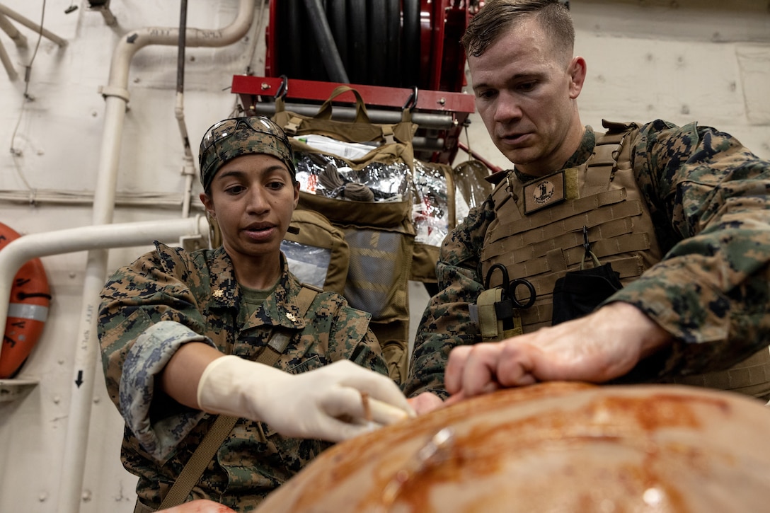 U.S. Navy Lt. Cmdr. Marissa Mayor, left, a general surgeon with 2nd Medical Battalion, 2nd Marine Logistics Group, demonstrates medical procedures to Hospital Corpsman 2nd Class Will Jones, assigned to 4th Light Armor Reconnaissance Battalion in support of Special Purpose Marine Air-Ground Task Force UNITAS LXIII, aboard the amphibious transport dock ship USS Mesa Verde (LPD 19) at a surgical training event during exercise UNITAS LXIII in the Atlantic Ocean, Sept. 17, 2022. The training event consisted of Marines patrolling, taking simulated casualties, and simulated lifesaving surgery. UNITAS is the world’s longest-running annual multinational maritime exercise that brings together forces from 19 countries to include Brazil, Cameroon, Chile, Colombia, Dominican Republic, Ecuador, France, Guyana, Jamaica, Mexico, Namibia, Panama, Paraguay, Peru, South Korea, Spain, the United Kingdom, the United States, and Uruguay. The exercise focuses on enhancing interoperability among multiple nations and joint forces during littoral and amphibious operations in order to build on existing regional partnerships and create new enduring relationships that promote peace, stability, and prosperity in the U.S. Southern Command’s area of responsibility. (U.S. Marine Corps photo by Sgt. Brendan Mullin)