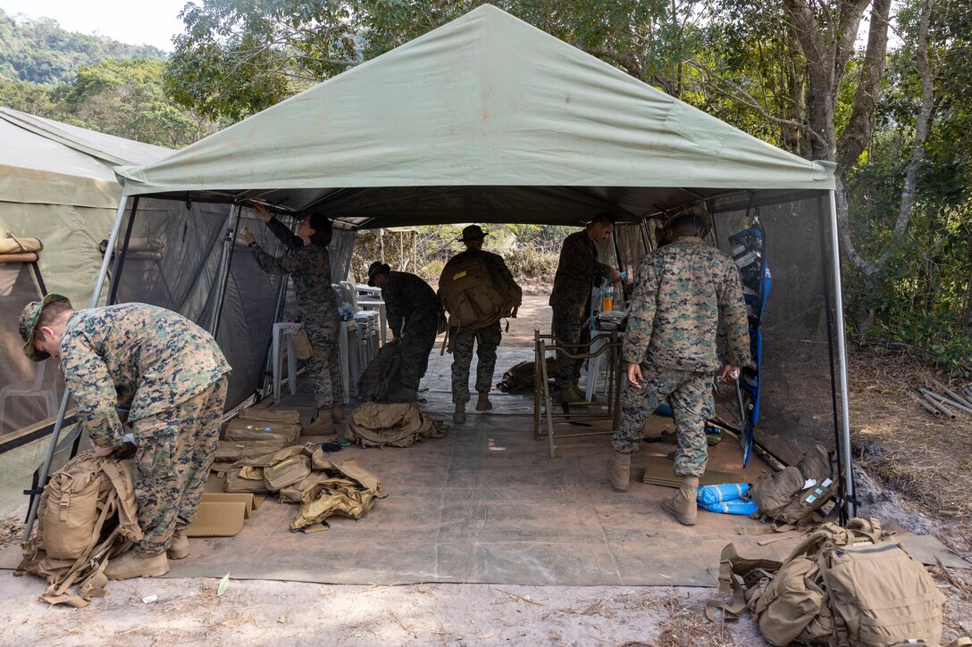 U.S. Sailors with 2nd Medical Battalion, 2nd Marine Logistics Group, in support of Special Purpose Marine Air-Ground Task Force UNITAS LXIII discuss medical equipment with Brazilian marines during a surgical training event during exercise UNITAS LXIII in Marambaia, Brazil, Sept. 10, 2022. The training event consisted of a medical equipment presentation, a field surgery, and a casualty evacuation via a Brazilian armored personnel carrier. UNITAS trains forces to conduct joint maritime operations through the execution of anti-surface, anti-submarine, anti-air, amphibious, and electronic warfare operations that enhance warfighting proficiency and increase interoperability among participating navy and marine forces. (U.S. Marine Corps photo by Lance Cpl. David Intriago)