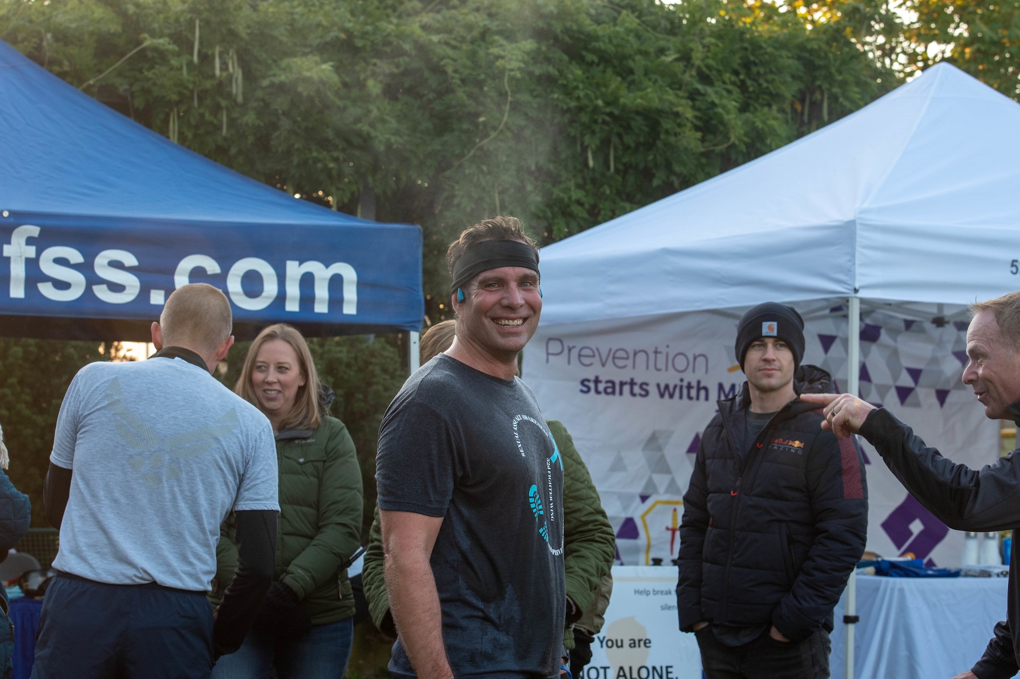 Man smiles at the camera after running.