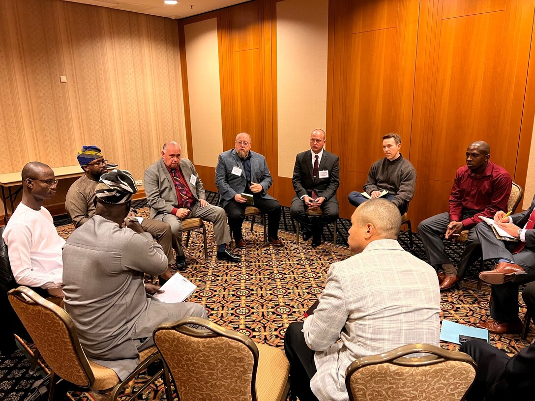 a large group sit in a circle talking