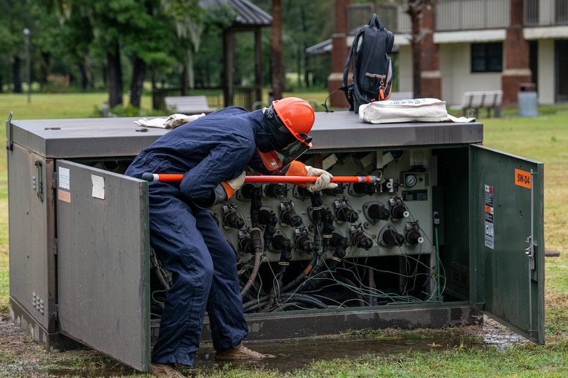 An Airman works on a power box