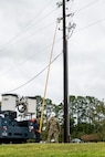 An Airman replaces a fuse on a power line