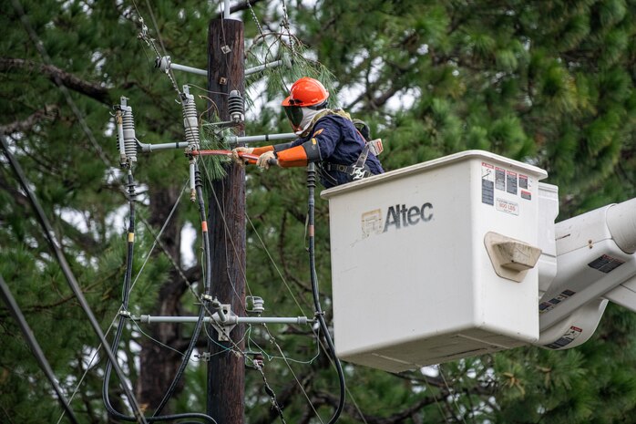 An Airman replaces a fuse on a power line.