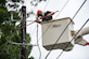 An Airman replaces a fuse on a power line