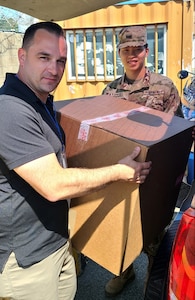 Personnel assigned to the U.S. Army Medical Materiel Center-Korea deliver boxes of ancillary kits for COVID-19 vaccine and booster administration to USS Ronald Reagan (CVN 76) during a Sept. 23 port visit to Busan, Republic of Korea. (U.S. Army photo by Staff Sgt. Camanita Ieremia)