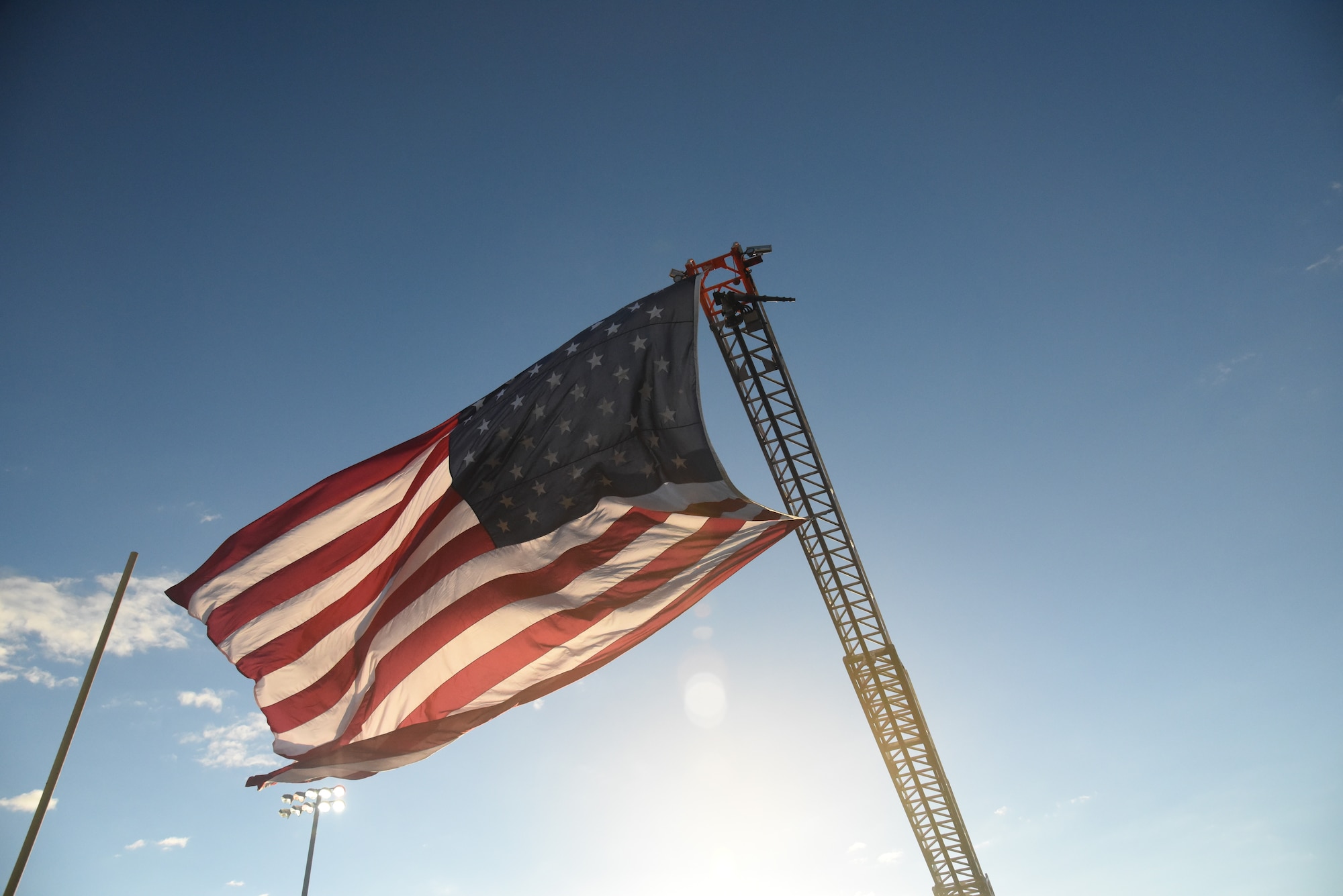 American flag flies high at football game.
