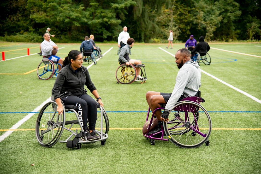 Athletes practice in their chairs while learning about wheelchair football.