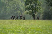 Airmen walk across a field.