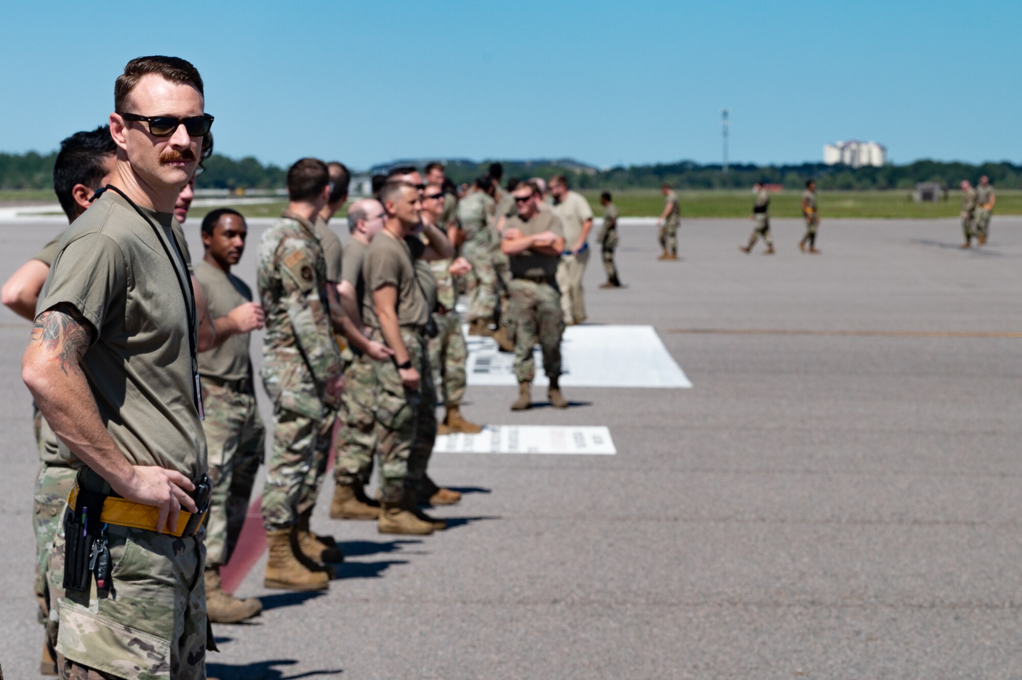 U.S. Airmen assigned to the 6th Maintenance Squadron finish picking up debris during a foreign object debris walk