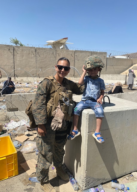 U.S. Marine Corps Sgt. Leilana TupuaRodriguez poses for a photo with a child hours before a suicide bomb explosion at Hamid Karzai International Airport, Kabul, Afghanistan, Aug. 26, 2021.