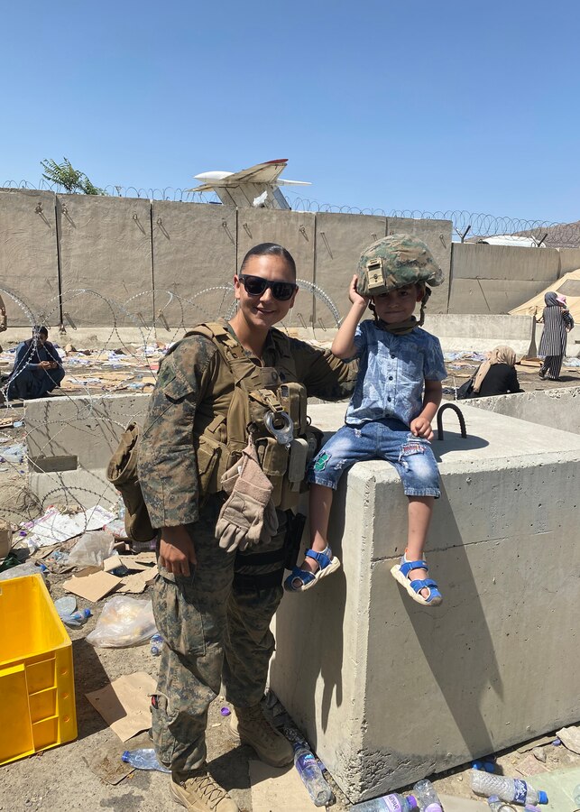 U.S. Marine Corps Sgt. Leilana TupuaRodriguez poses for a photo with a child hours before a suicide bomb explosion at Hamid Karzai International Airport, Kabul, Afghanistan, Aug. 26, 2021. TupuaRodriguez, a native of Bremerton, Washington, received the Jim Kallstrom Award for her bravery while serving as a criminal investigator with the 24th Marine Expeditionary Unit, supporting evacuations during the bombing in Kabul that took the life of 13 service members in August 2021. Courtesy Photo