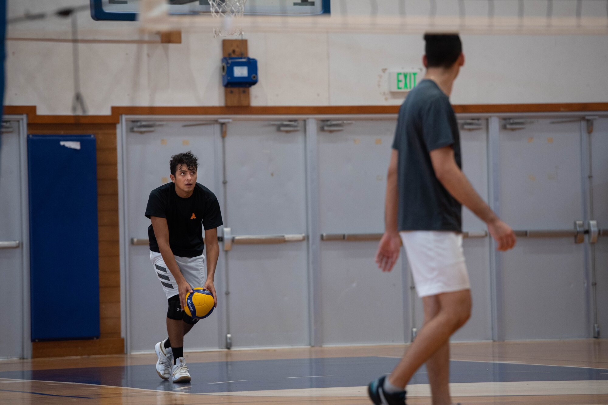 An Airman serves a volleyball.