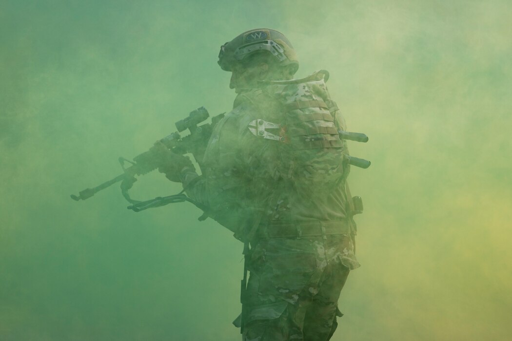 An Airman stands in a smog of green smoke