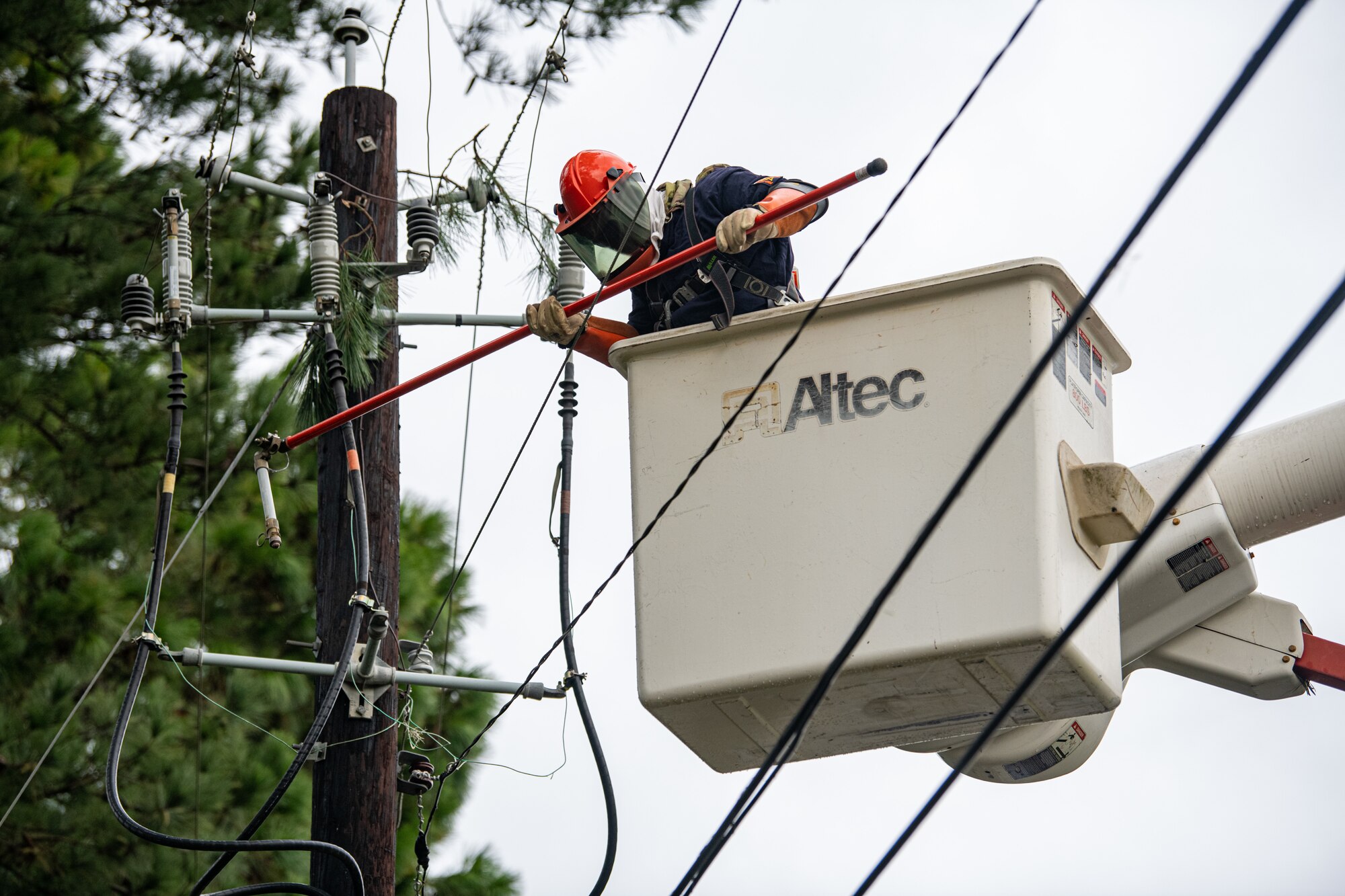 An Airman replaces a fuse on a power line