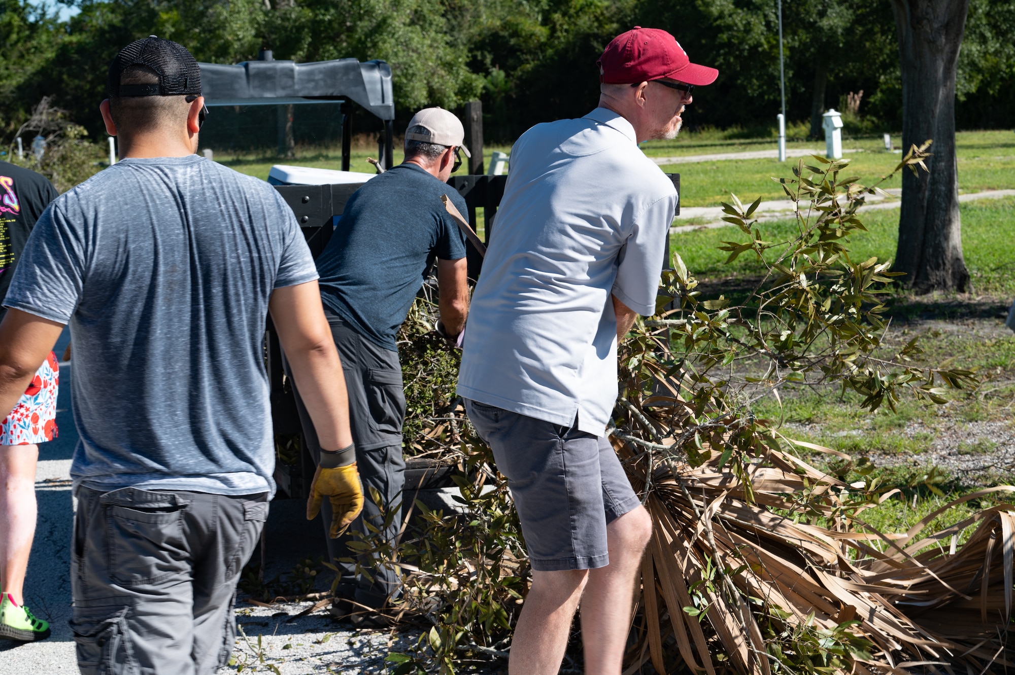 Members of MacDill outdoor recreation pick up fallen branches at MacDill Air Force Base