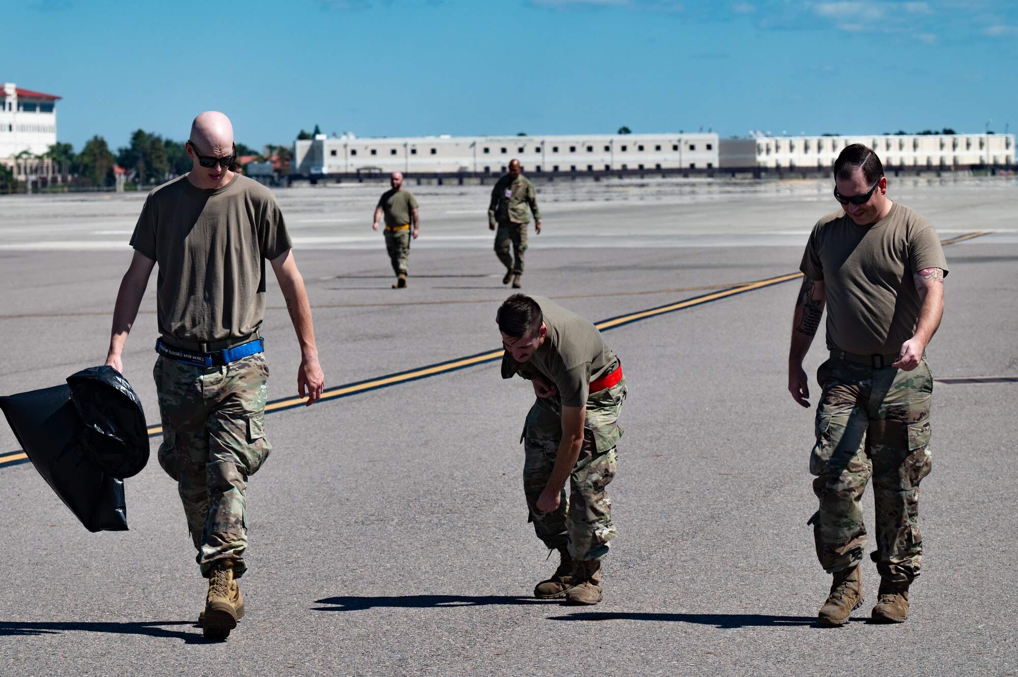 U.S. Airmen assigned to the 6th Maintenance Squadron pick up debris during a foreign object debris walk