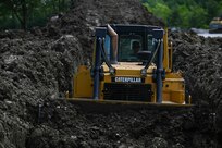 An Airman from the 11th Wing Civil Engineering Squadron operates a bulldozer during a Bivouac training exercise at Fort Indiantown Gap, Pennsylvania, May 25, 2022. The Bivouac entails multiple hands-on training opportunities and setting up a bare base. (U.S. Air Force photo by Airman Bill Guilliam)