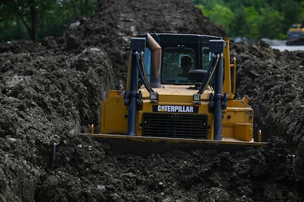 An Airman from the 11th Wing Civil Engineering Squadron operates a bulldozer during a Bivouac training exercise at Fort Indiantown Gap, Pennsylvania, May 25, 2022. The Bivouac entails multiple hands-on training opportunities and setting up a bare base. (U.S. Air Force photo by Airman Bill Guilliam)