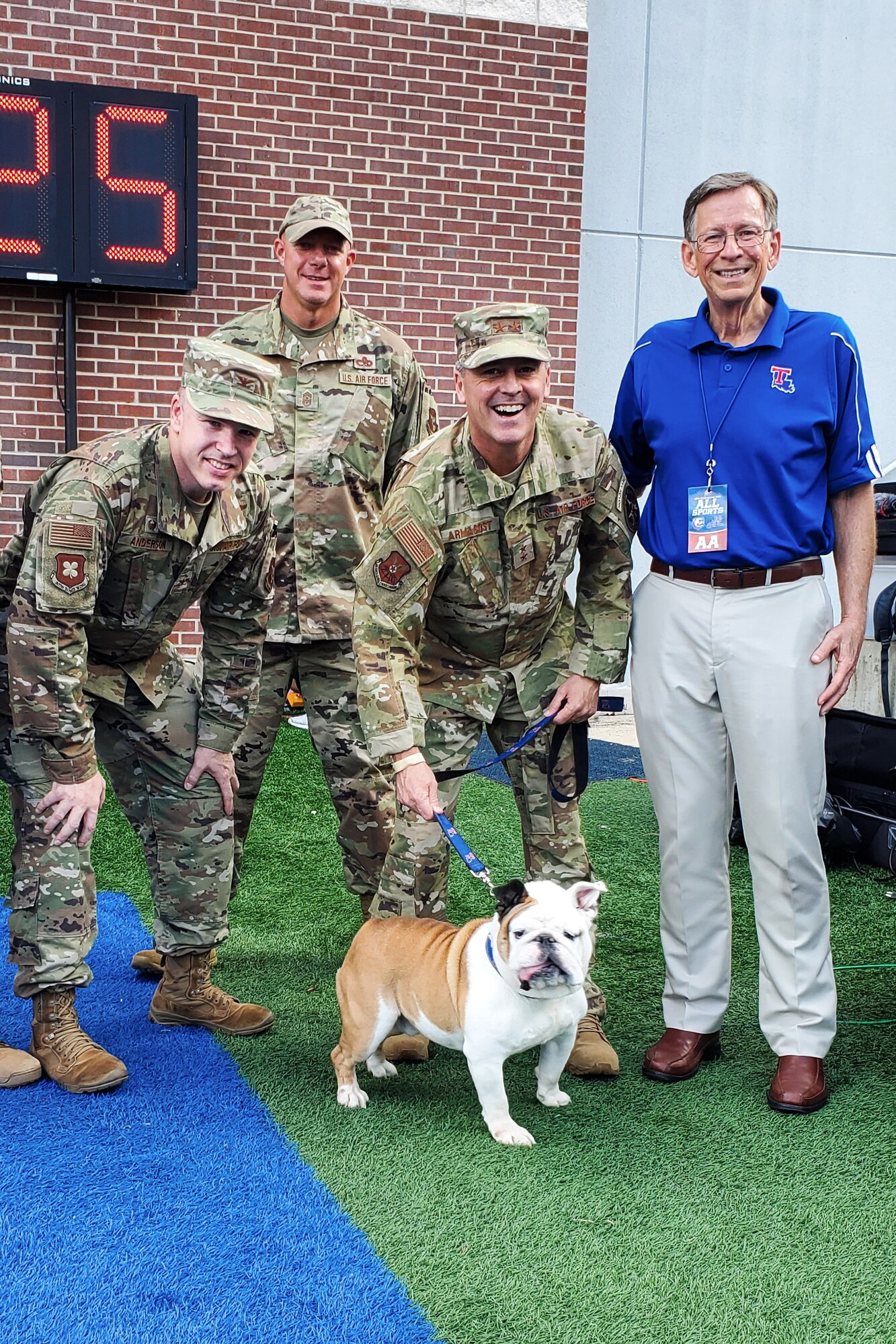 Photo of Airman smiling and posing with a bulldog