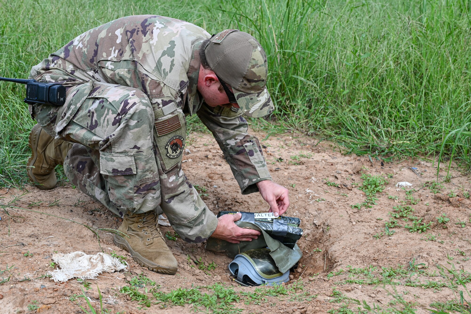 An Airmen place a munition in the ground