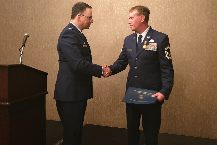 Senior Master Sgt. Richard Fanning Jr. (right) of the 193rd Special Operations Wing is congratulated by Col. Deane Thomey, commander of the 111th Attack Wing, during the Maj. Octavius V. Catto award ceremony Oct. 1 at the Union League of Philadelphia.