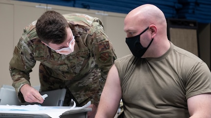 U.S. Air Force Senior Airman Aiden Tate, 316th Medical Squadron family practice technician, administers the Moderna COVID-19 vaccination to Capt. Cooper Emmons, 11th Security Forces Squadron operations officer, at Joint Base Anacostia-Bolling, Washington D.C., Dec. 30, 2020. As initial quantities of the vaccine are limited, medical, fire department and security forces professionals are the first at JBAB to be offered the vaccine in line with the Department of Defense phased prioritization plan. When available, the DOD will ensure the vaccine is available for all beneficiaries. (U.S. Air Force photo by Staff Sgt. Stuart Bright)