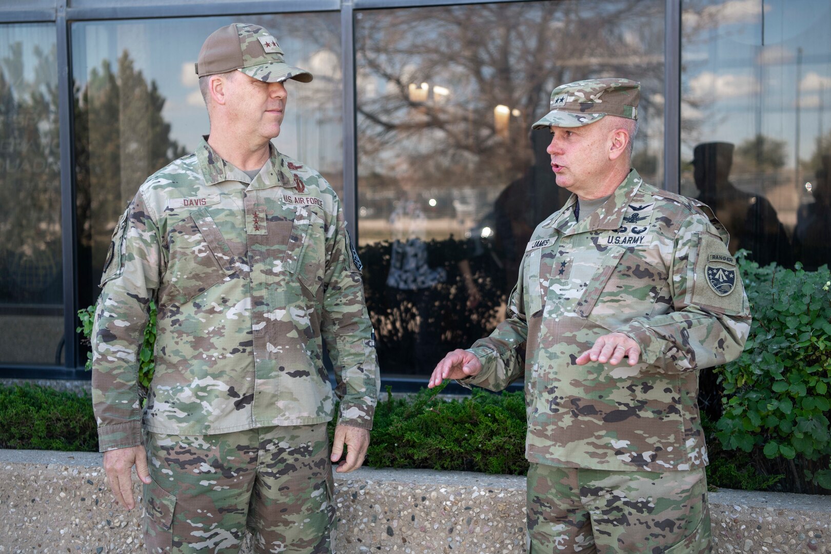 Two men in military uniforms speak to eachother