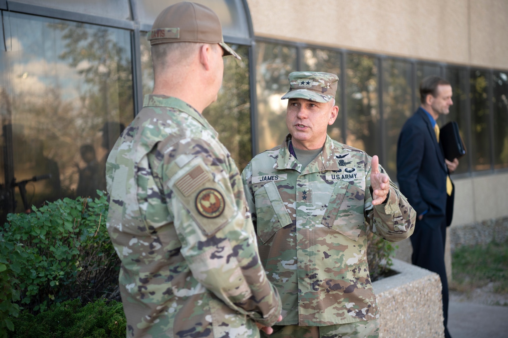 Two men in military uniforms speak to eachother