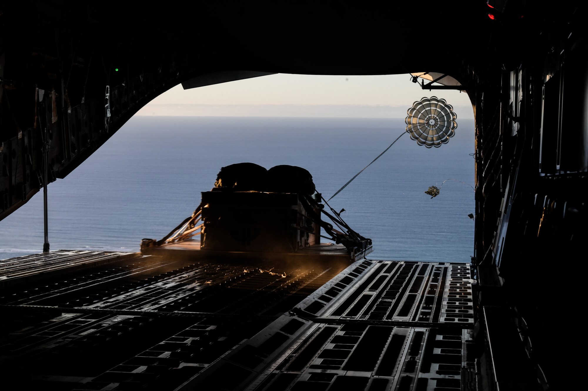 Cargo is released from a C-17 Globemaster III assigned to the 15th Operations Group during a bilateral exercise around the Hawaiian Islands, Sept. 28, 2022. The training was held to further the capabilities, procedures and best practices of the C-17 and the Kawasaki C-2 to utilize in future interoperable missions.(U.S. Air Force photo by Staff Sgt. Alan Ricker)