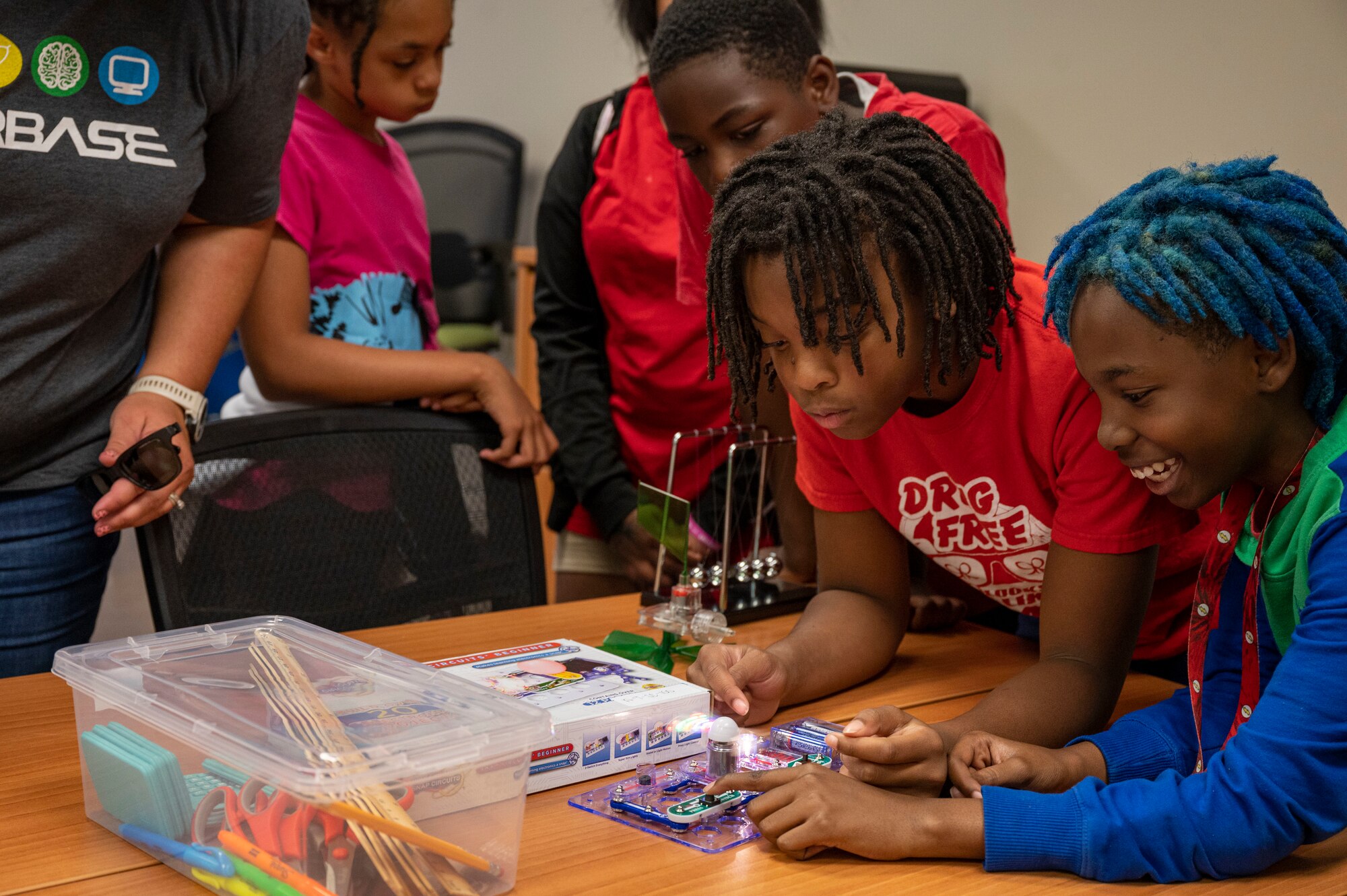 Children play with a circuit board in a classroom