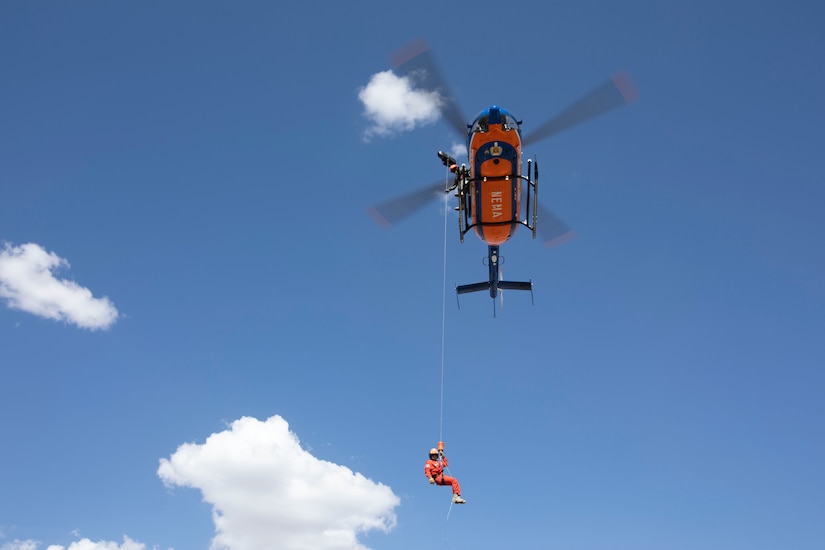 A Mongolia National Emergency Management Agency team lowers from a helicopter to hoist a basket stretcher during a simulated search and rescue scenario as part of Gobi Wolf 2022 in Bayankhongor, Mongolia, Sept. 8. Gobi Wolf is a disaster response exercise conducted as a humanitarian assistance and disaster relief engagement. The field training exercise focuses on hazardous material response, mass medical care, and search and rescue. (Alaska National Guard photo by Victoria Granado)