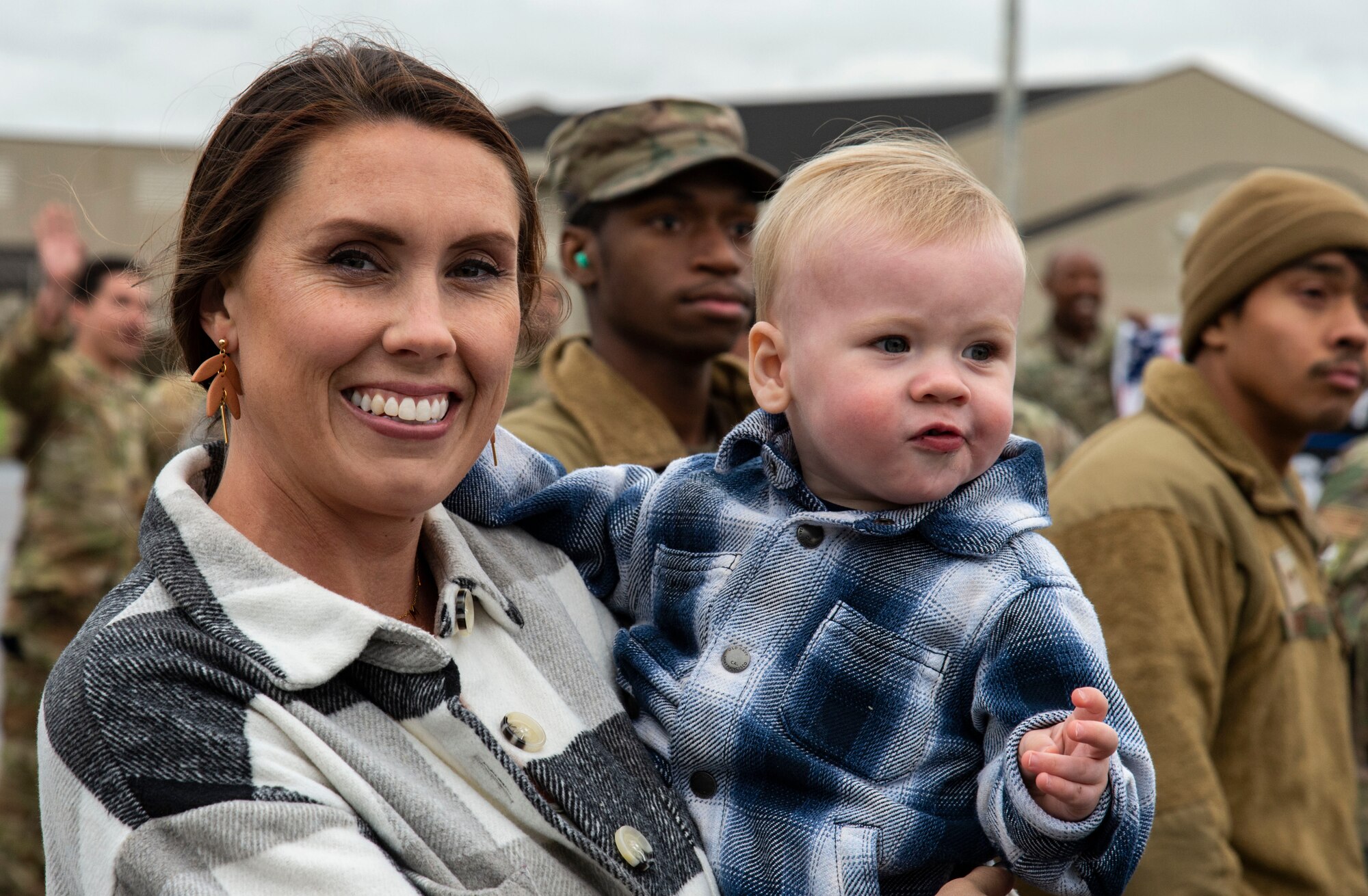 Amanda and Beau Bertelson, wife and son of Capt. Ben Bertelson, 3rd Airlift Squadron C-17 Globemaster III pilot, wait for him to deplane at Dover Air Force Base, Delaware, Oct. 3, 2022. Members from the 3rd AS, 436th Mission Generation Group and 436th Security Forces Squadron were greeted by family, fellow squadron and Team Dover members after a deployment to Al Udeid Air Base, Qatar. (U.S. Air Force photo by Roland Balik)