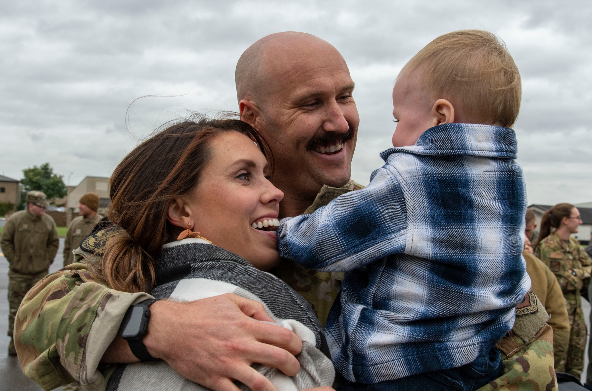 Capt. Ben Bertelson, center, 3rd Airlift Squadron C-17 Globemaster III pilot, hugs his wife Amanda and son Beau upon returning to Dover Air Force Base, Delaware, Oct. 3, 2022. Members from the 3rd AS, 436th Mission Generation Group and 436th Security Forces Squadron were greeted by family, fellow squadron and Team Dover members after a deployment to Al Udeid Air Base, Qatar. (U.S. Air Force photo by Roland Balik)