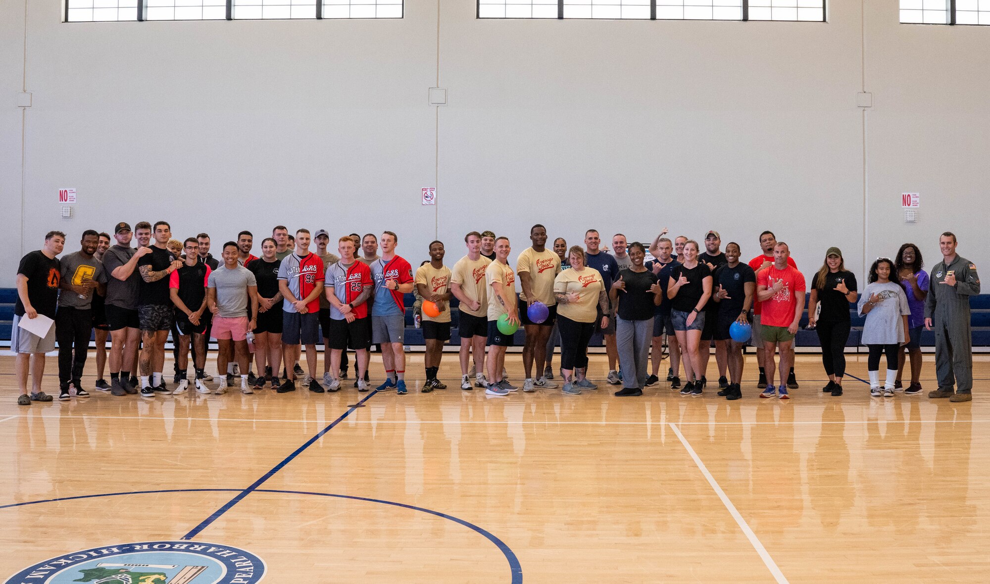 Tournament coordinators and players pose for a group photo before the violence prevention dodgeball tournament at Joint Base Pearl Harbor-Hickam, Hawaii, Sept. 30 2022. The event was held at JBPHH Gym to raise awareness for Suicide Prevention Month. (U.S. Air Force photo by Senior Airman Makensie Cooper)