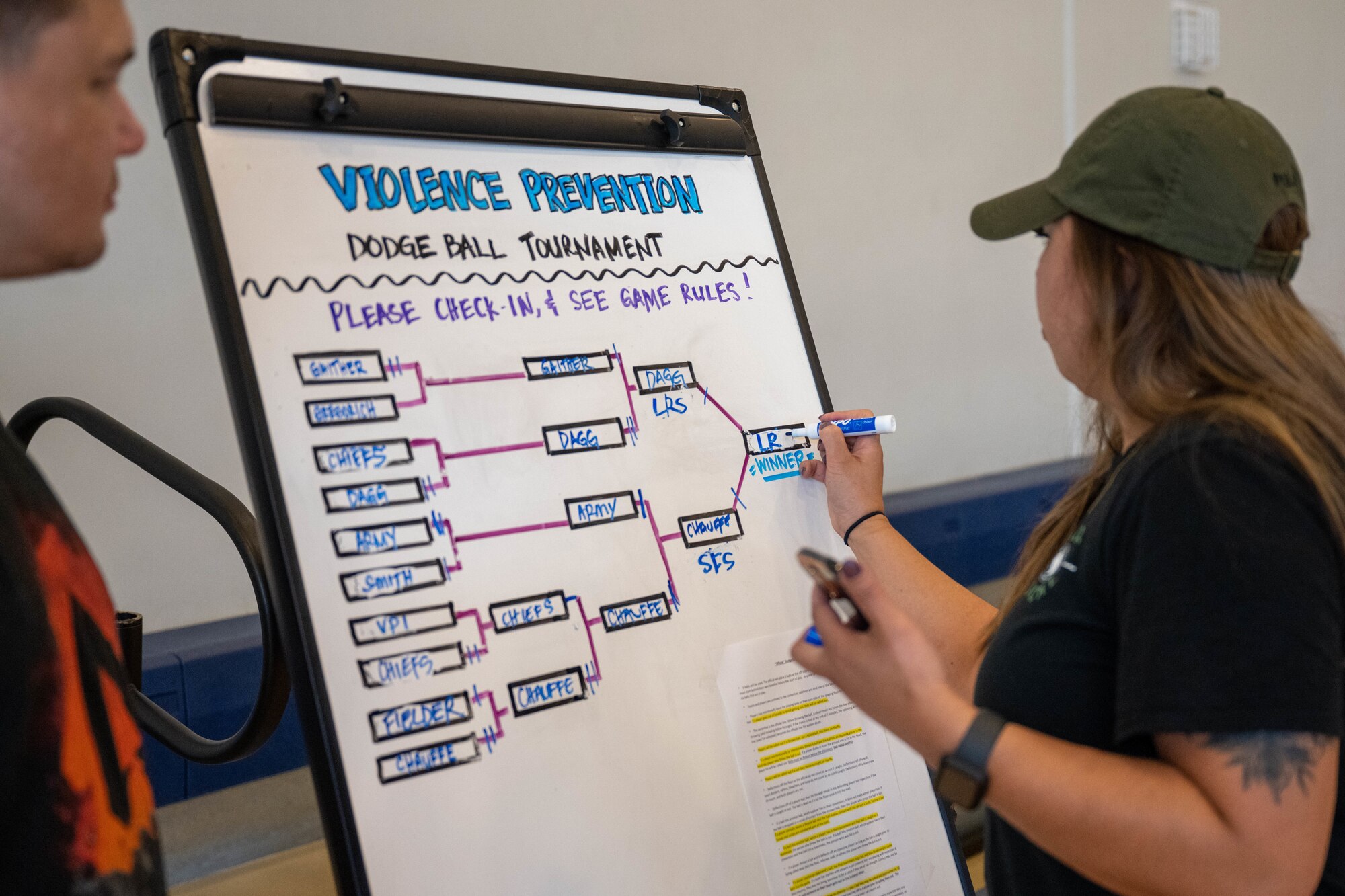 Master Sgt. Rachel Sungahid, 15th Wing Violence Prevention Office violence prevention integrator, writes the name of the winning team in the bracket at Joint Base Pearl Harbor-Hickam, Hawaii, Sept. 30, 2022. The Violence Prevention Office coordinated the tournament to increase awareness of Suicide Prevention Month. (U.S. Air Force photo by Senior Airman Makensie Cooper)