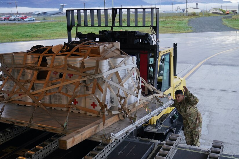 Alaska Air National Guardsmen of 144th Airlift Squadron and 176th Logistics Readiness Squadron load relief supplies bound for Nome Sept. 30, 2022, on a C-17 Globemaster III. More than 130 members of the Alaska Organized Militia, which includes members of the Alaska National Guard, Alaska State Defense Force and Alaska Naval Militia, were activated following a disaster declaration issued Sept. 17 after the remnants of Typhoon Merbok caused dramatic flooding across more than 1,000 miles of Alaskan coastline.  (Alaska National Guard photo by Dana Rosso)