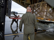 Alaska Air National Guardsmen of 211th Rescue Squadron and 176th Logistics Readiness Squadron load relief supplies bound for Bethel Sept. 29, 2022, on an HC-130J Combat King II. More than 130 members of the Alaska Organized Militia, which includes members of the Alaska National Guard, Alaska State Defense Force and Alaska Naval Militia, were activated following a disaster declaration issued Sept. 17 after the remnants of Typhoon Merbok caused dramatic flooding across more than 1,000 miles of Alaskan coastline. (Alaska Air National Guard photo by David Bedard)