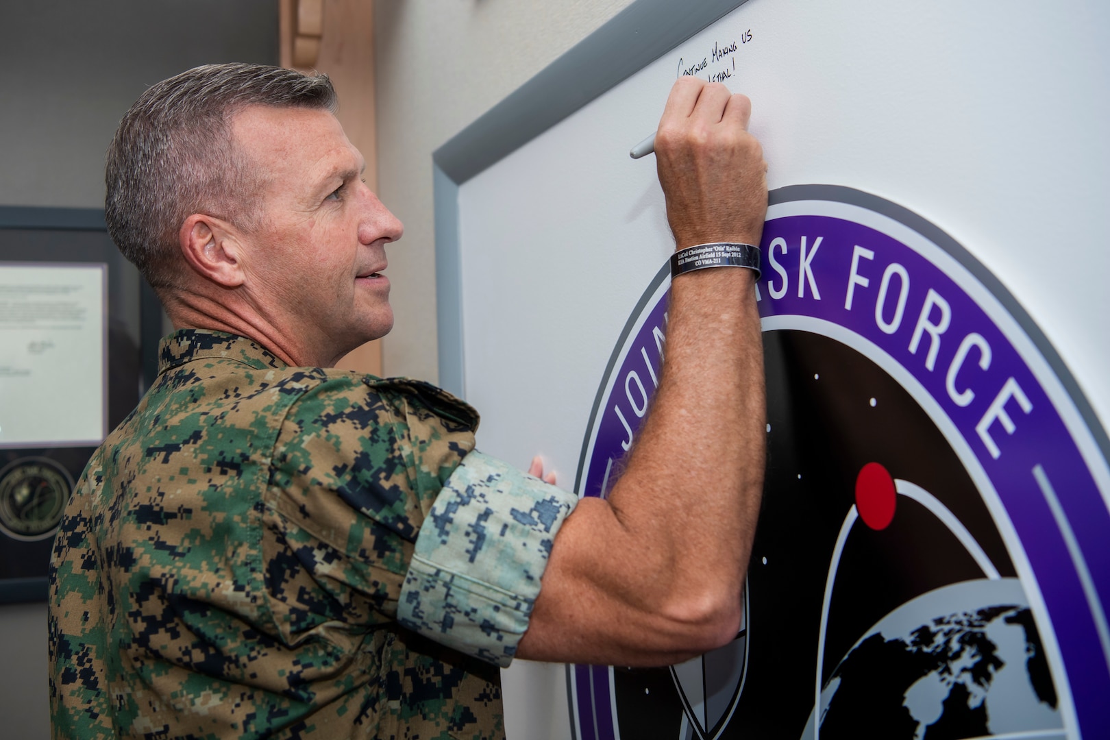 Marine in uniform signing board